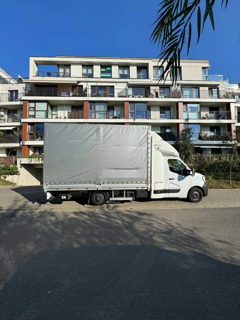 Pracownicy firmy przeprowadzki noszą meble w Warszawie