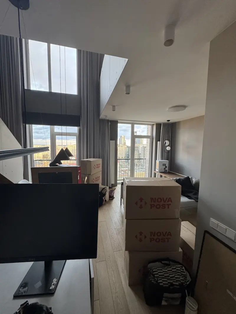 Stos kartonów kurierskich Nova Post przygotowanych do wysyłki lub przeprowadzki w jasnym salonie