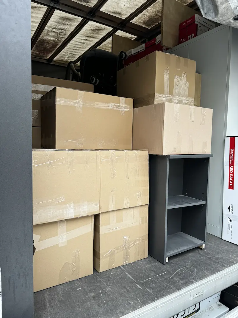 Wnętrze samochodu dostawczego wypełnione kartonami i meblami