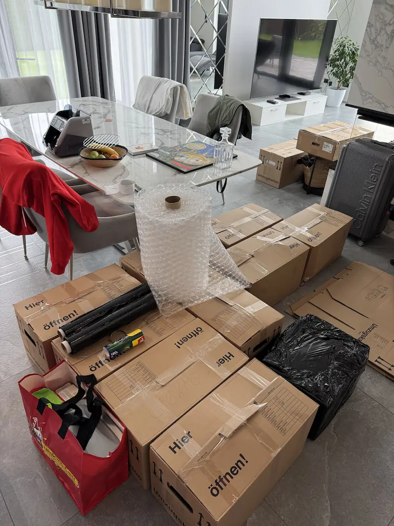 Salon przygotowany do przeprowadzki z kartonami, folią bąbelkową i folią stretch